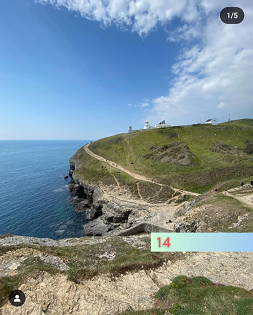 A coastal path with green grass a bright blue sky